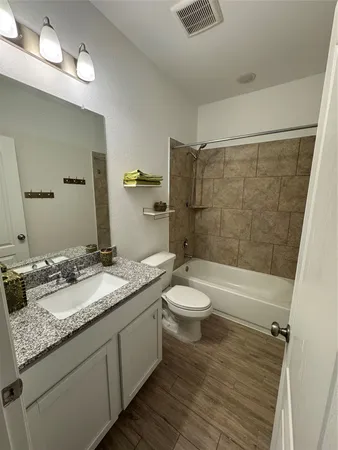 a bathroom with a granite countertop sink toilet and shower