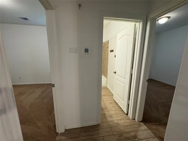 a view of a hallway with wooden floor