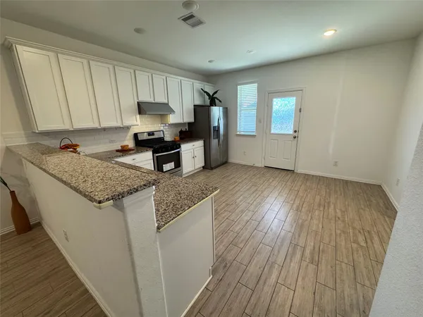a kitchen with granite countertop wooden cabinets a sink and dishwasher