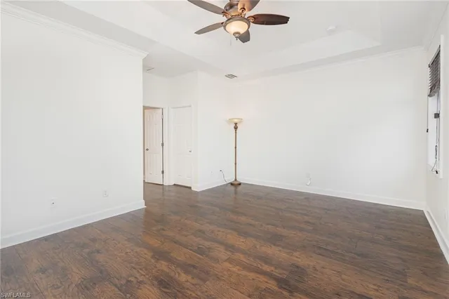 a view of a room with wooden floor and a ceiling fan
