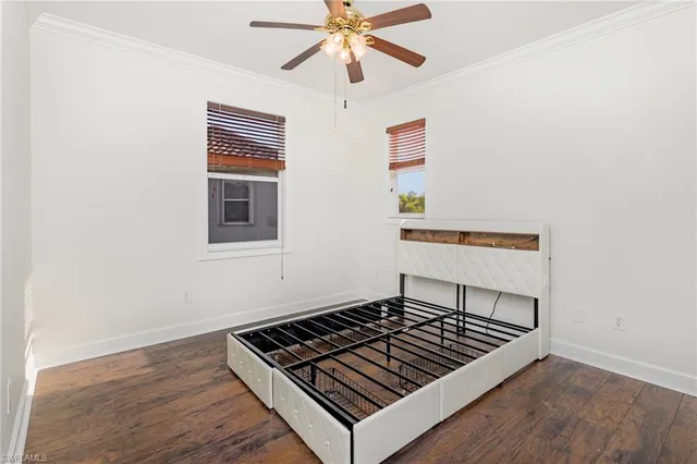 an empty room with wooden floor and ceiling fan