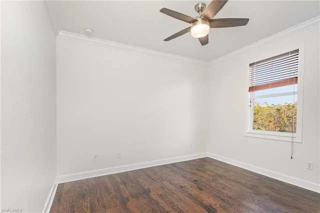 an empty room with a window and a ceiling fan