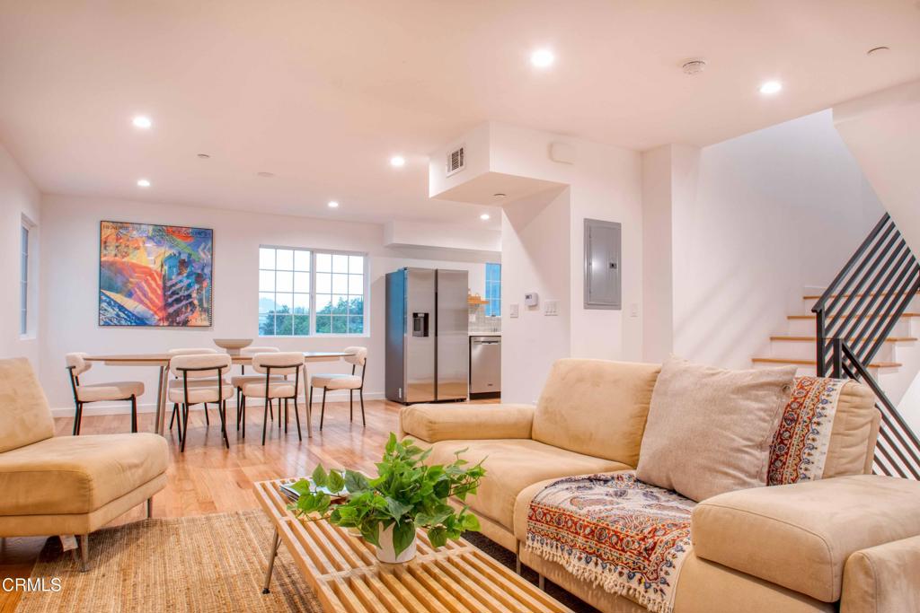 a living room with furniture and a wooden floor