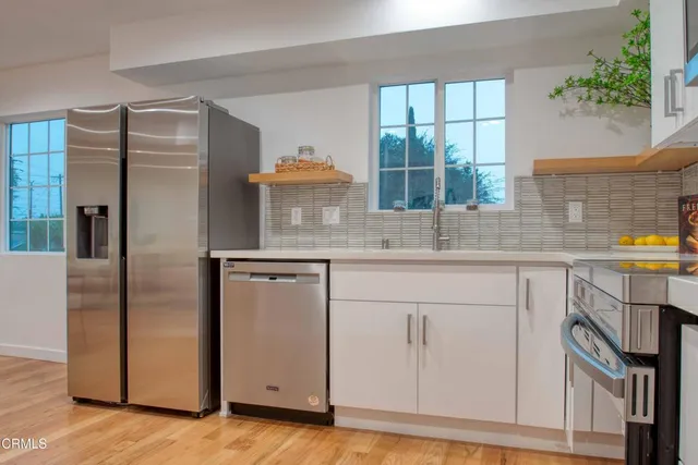 a kitchen with stainless steel appliances granite countertop a refrigerator and a sink