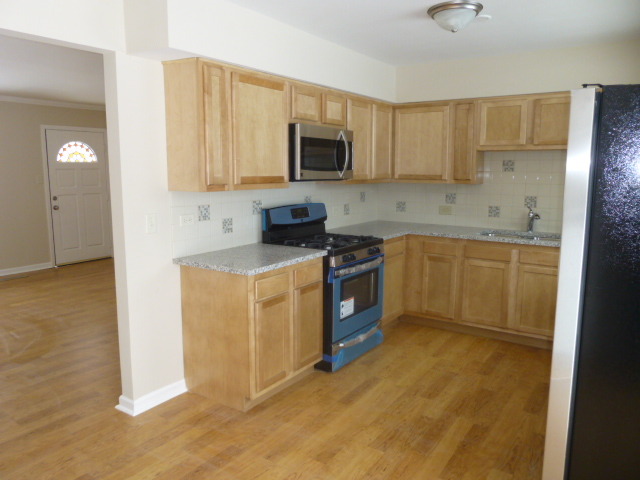 577 Redwood Road Bolingbrook, IL 60440 - Photo 4 of 20 a kitchen with stainless steel appliances granite countertop a stove a sink and a microwave