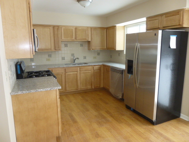 577 Redwood Road Bolingbrook, IL 60440 - Photo 5 of 20 a kitchen with a refrigerator sink and cabinets