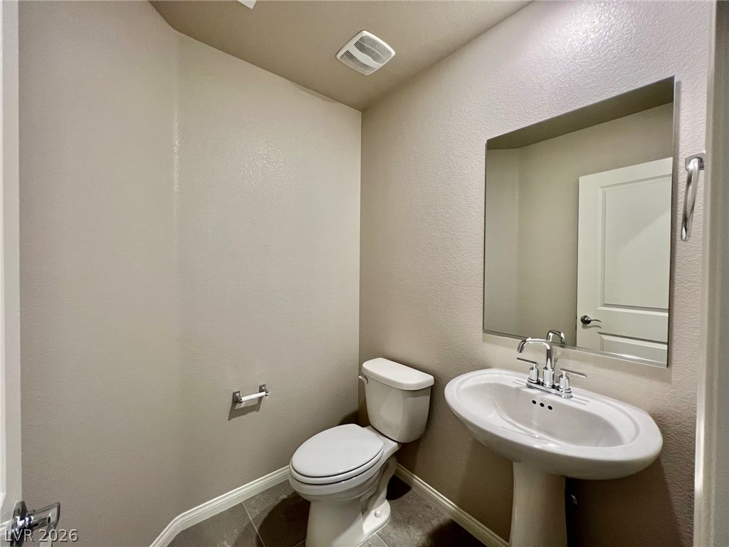 7845 Morganite Avenue Las Vegas, NV 89113 - Photo 12 of 21 A well-appointed powder room with a sleek pedestal sink and contemporary finishes.