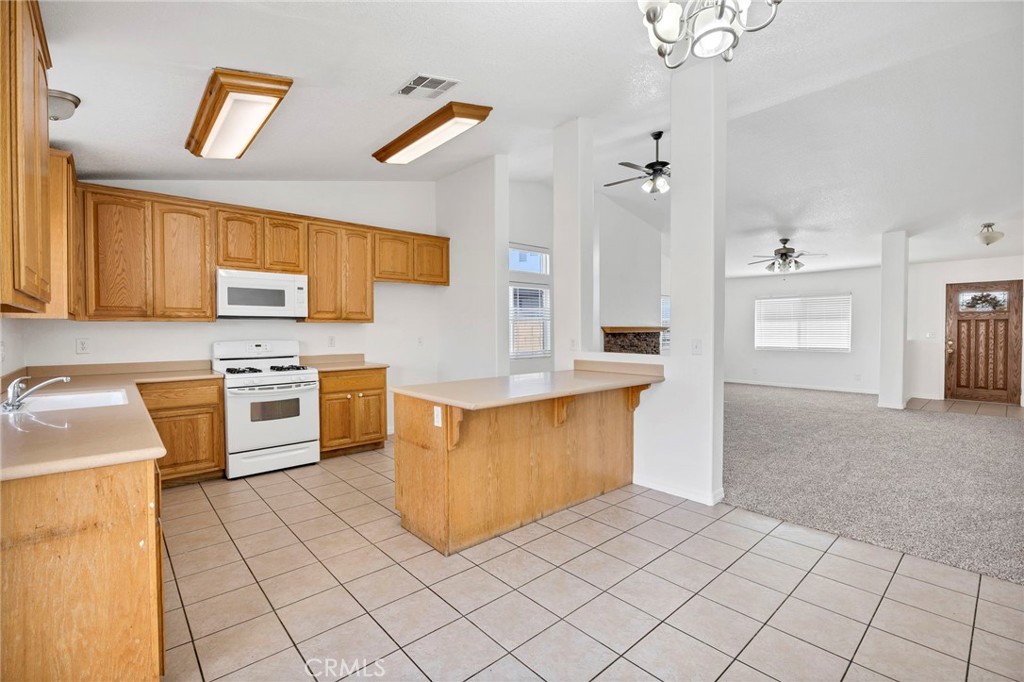 1230 Shellie Lane Hemet, CA 92543 - Photo 12 of 44 a kitchen with stainless steel appliances a stove a sink and a refrigerator