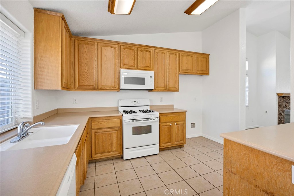 1230 Shellie Lane Hemet, CA 92543 - Photo 14 of 44 a kitchen with a sink stove and cabinets