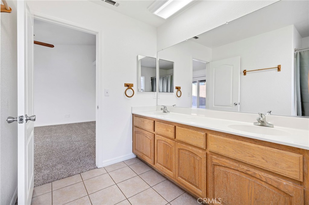 1230 Shellie Lane Hemet, CA 92543 - Photo 23 of 44 a spacious bathroom with a granite countertop sink a mirror and a