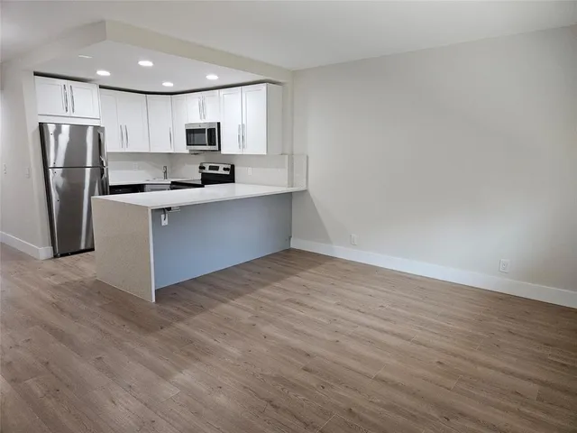 a kitchen with stainless steel appliances granite countertop a refrigerator sink and cabinets