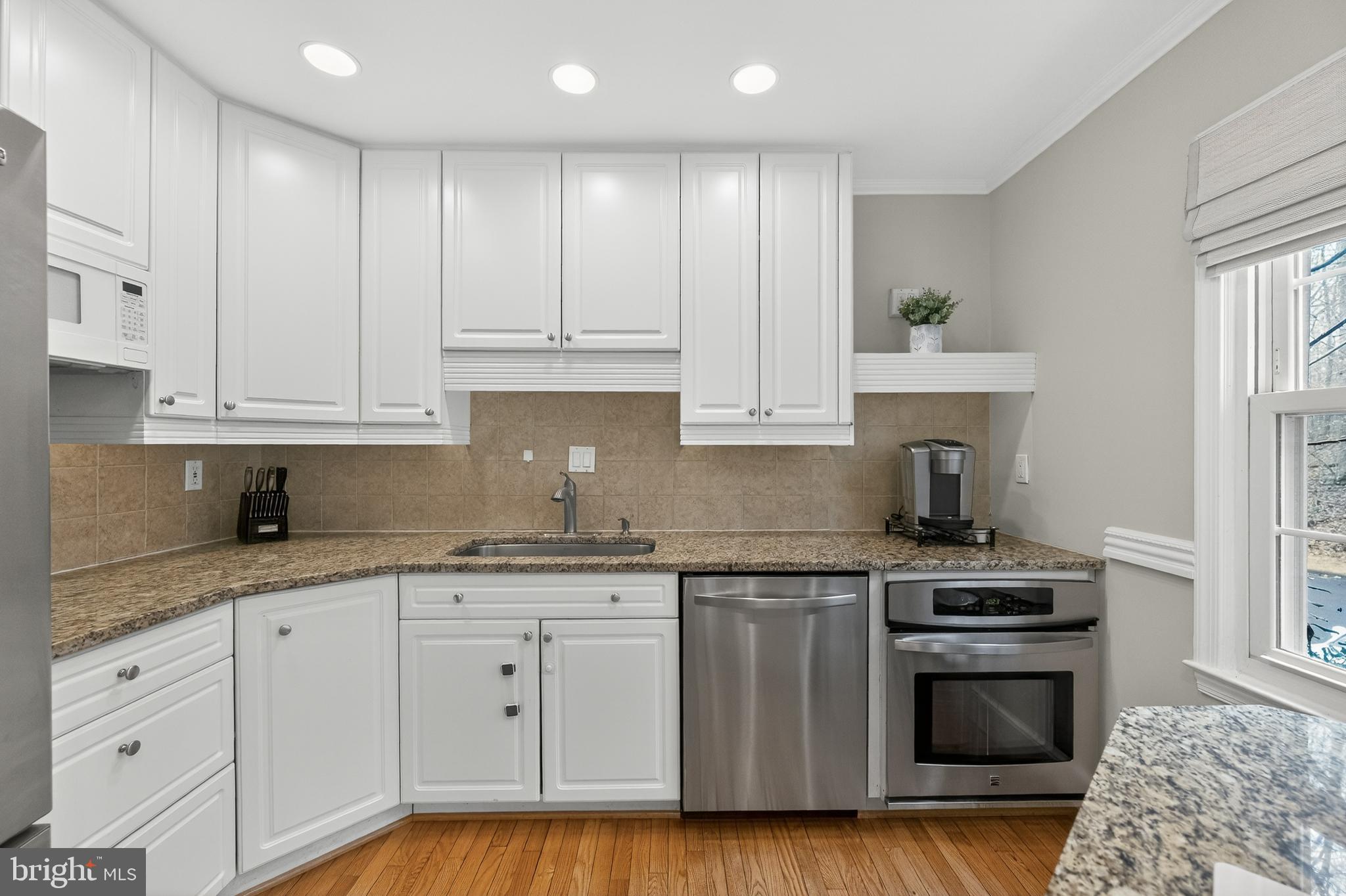 5624 Kirkham Court Springfield, VA 22151 - Photo 6 of 52 a kitchen with granite countertop white cabinets and stainless steel appliances