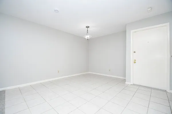 an empty room with white walls and fan