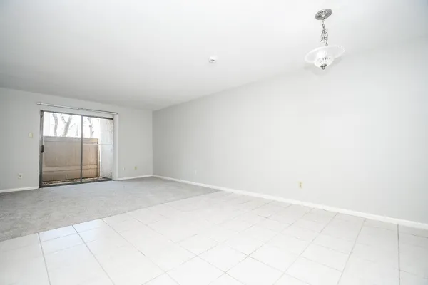 an empty room with windows and cabinet