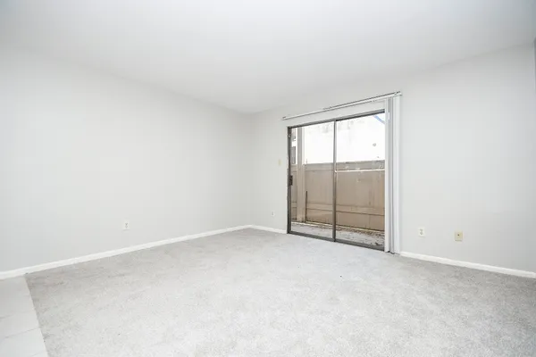 an empty room with wooden floor and sliding door