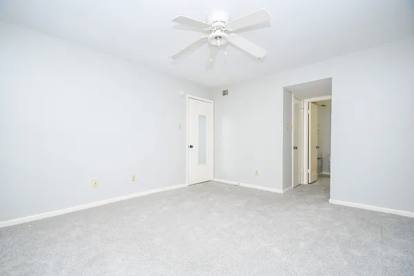 an empty room with a ceiling fan and a window