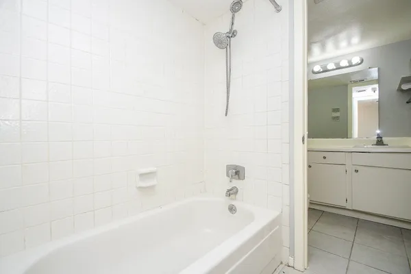 a bathroom with a bathtub a sink a vanity and a shower