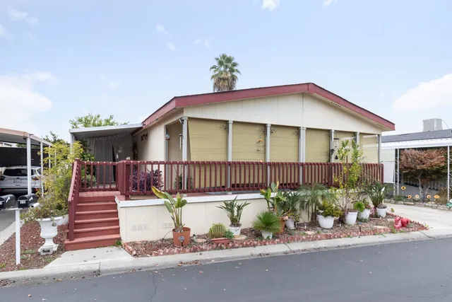 a front view of a house with a yard and potted plants