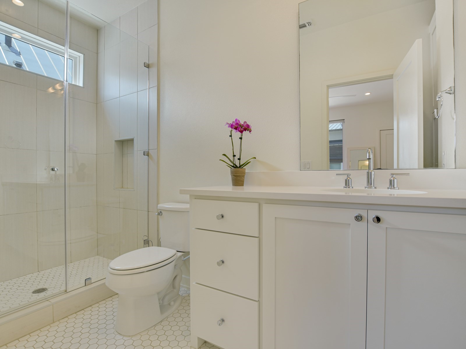 2610 Watkins Way Austin, TX 78746 - Photo 18 of 23 a bathroom with a shower sink vanity mirror and toilet