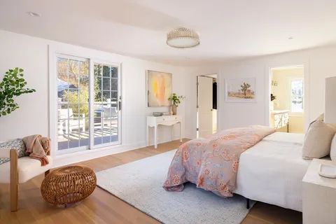 a spacious bedroom with a bed and wooden floor