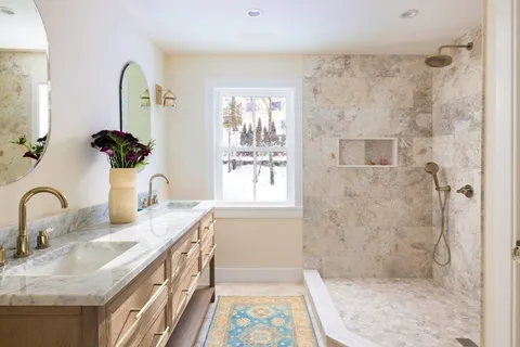 a bathroom with a granite countertop sink a mirror and shower