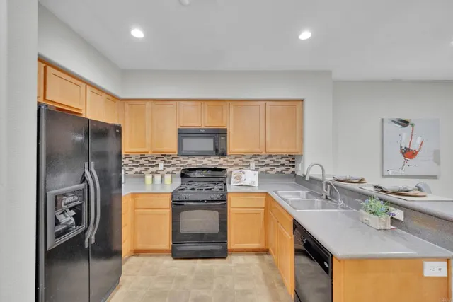 a kitchen with stainless steel appliances granite countertop a sink stove refrigerator and a window