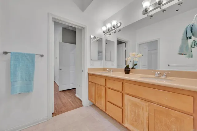 a spacious en suite bathroom with a double vanity sink and mirror
