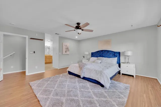 a spacious bedroom with a bed and a ceiling fan