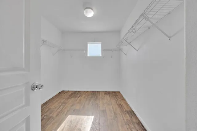 a view of a room with wooden floor and white walls