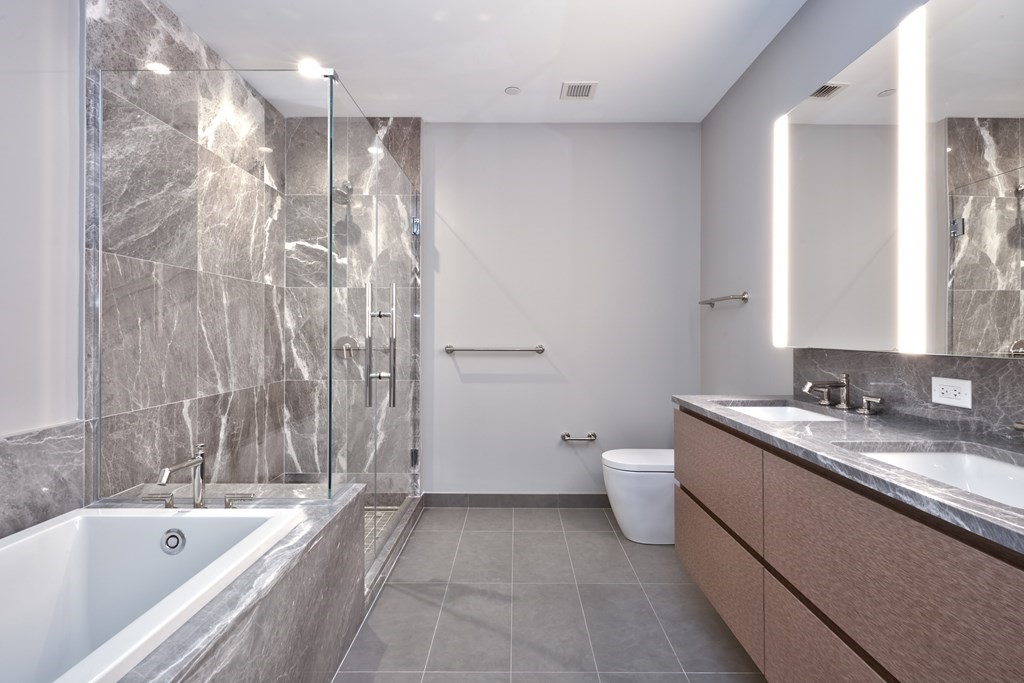 135 Seaport Boulevard, Unit PH3A Boston, MA 02210 - Photo 11 of 11 a bathroom with a granite countertop sink a toilet and bathtub