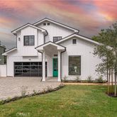 a front view of a house with a yard and trees