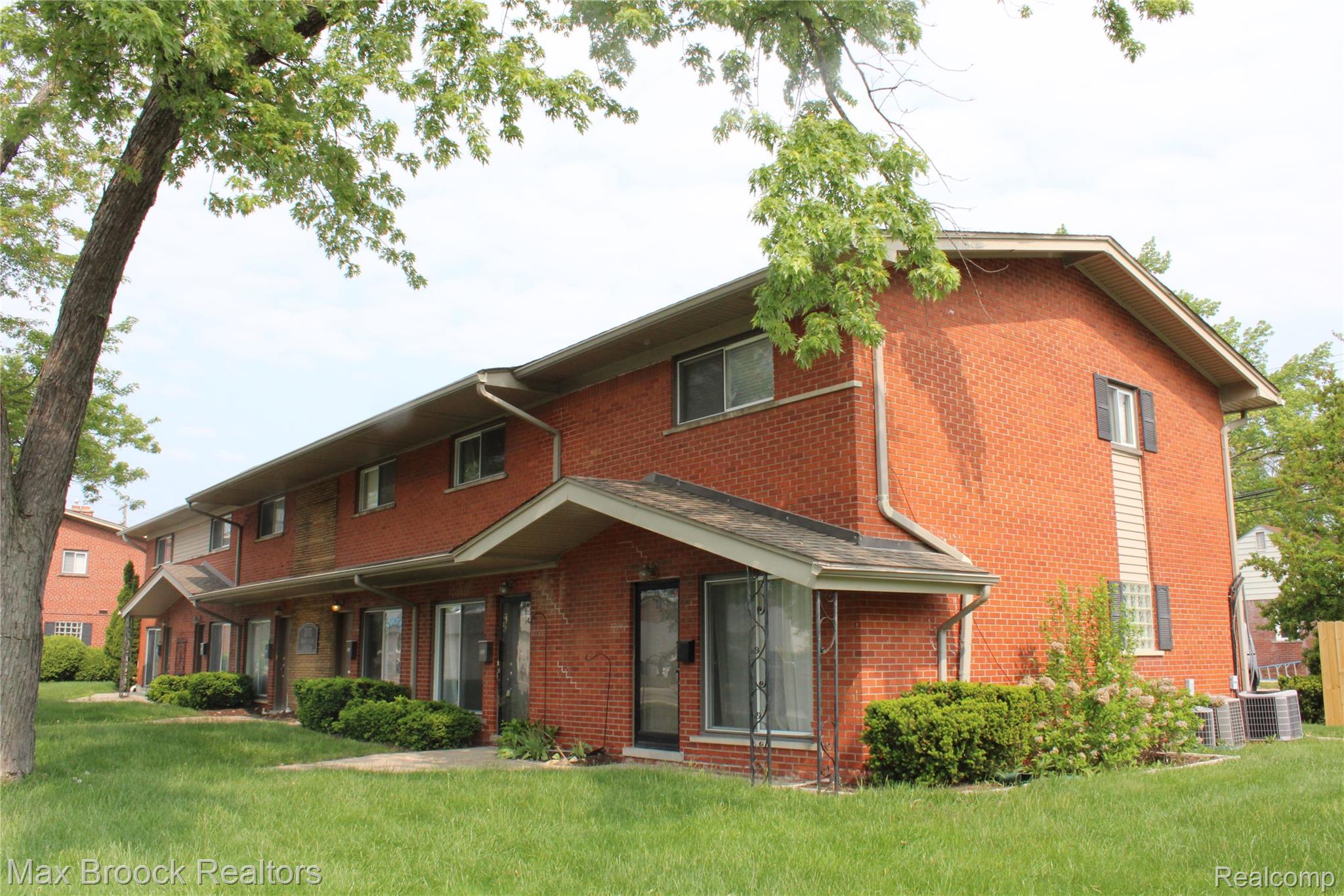 3800 Normandy Road, Unit 2 Royal Oak, MI 48073 - Photo 1 of 11 Brick exterior with white trim, covered entry, and individual air conditioning units