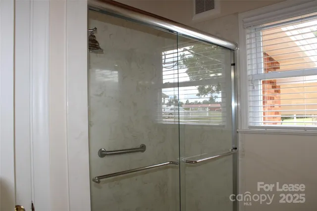a bathroom with a glass shower door