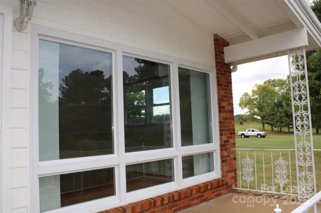a view of a balcony with wooden floor and garden