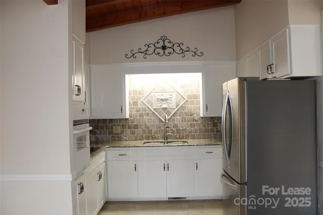 a kitchen with stainless steel appliances granite countertop a refrigerator and a stove