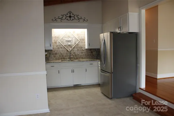 a kitchen with stainless steel appliances granite countertop a refrigerator and a stove top oven