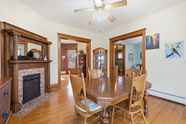 a dining room with furniture a fireplace and wooden floor