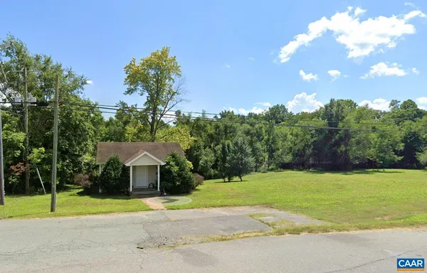 a view of a house with a yard and basketball court