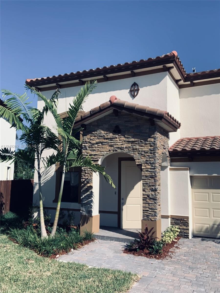 a front view of a house with plants