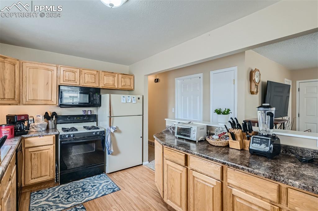 3103 Galley Road Colorado Springs, CO 80909 - Photo 6 of 25 a kitchen with granite countertop kitchen island stainless steel appliances a stove sink and cabinets