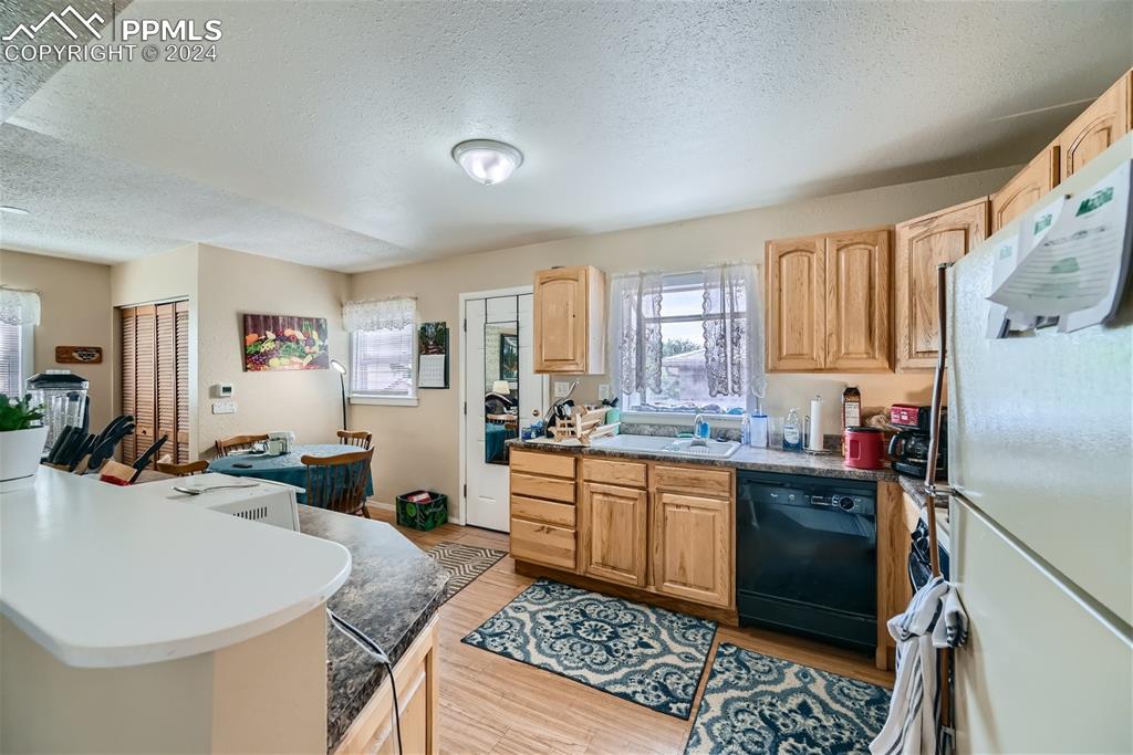 3103 Galley Road Colorado Springs, CO 80909 - Photo 7 of 25 a kitchen with a sink refrigerator and cabinets