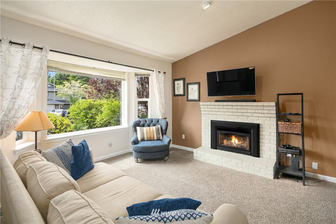 2329 169th Place Southeast Bothell, WA 98012 - Photo 3 of 18 a living room with furniture a flat screen tv and a fireplace