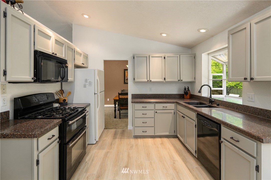 2329 169th Place Southeast Bothell, WA 98012 - Photo 7 of 18 a kitchen with stainless steel appliances a stove sink microwave and cabinets