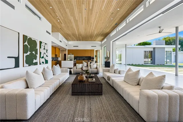 a large white kitchen with a large window and stainless steel appliances
