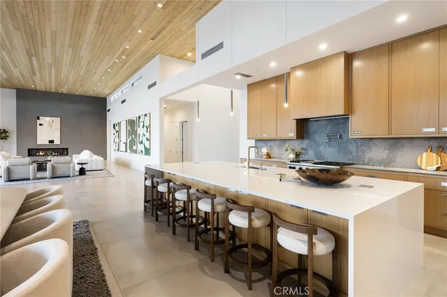 a large white kitchen with sink and view living room