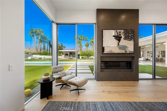 a view of pool with lawn chairs and large trees