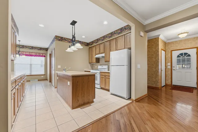 a kitchen with stainless steel appliances granite countertop a refrigerator a sink and a stove
