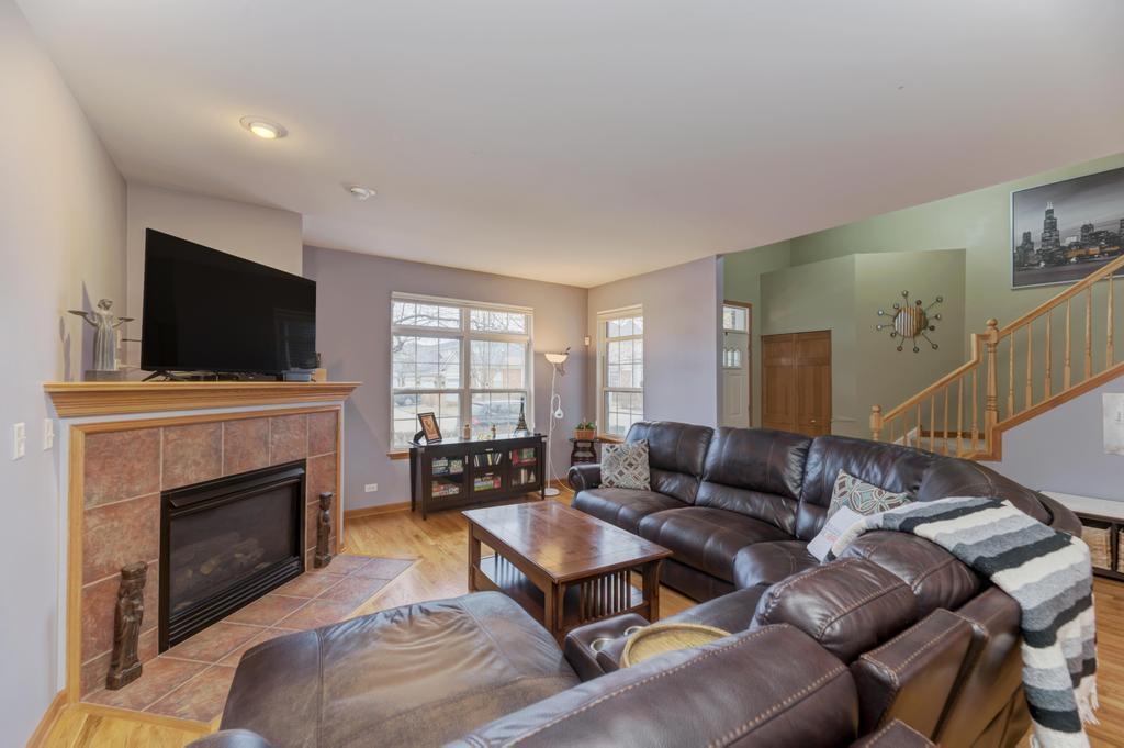 1846 Keystone Place Schaumburg, IL 60193 - Photo 6 of 30 a living room with furniture a flat screen tv and a fireplace