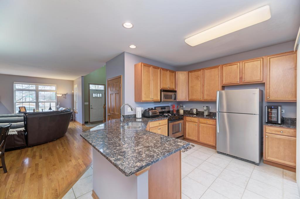 1846 Keystone Place Schaumburg, IL 60193 - Photo 10 of 30 a kitchen with refrigerator a stove a sink dishwasher and wooden cabinets with wooden floor