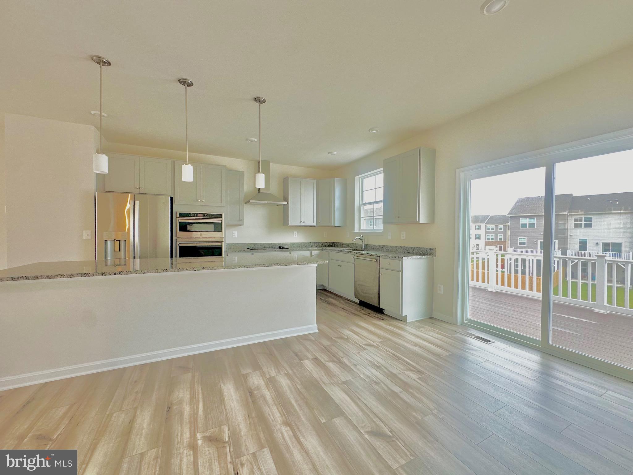153 Telluride Way Charles Town, WV 25414 - Photo 5 of 21 a large white kitchen with wooden floors and white stainless steel appliances